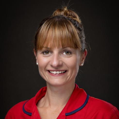 Smiling woman in red uniform with St Michael's Hospice logo.