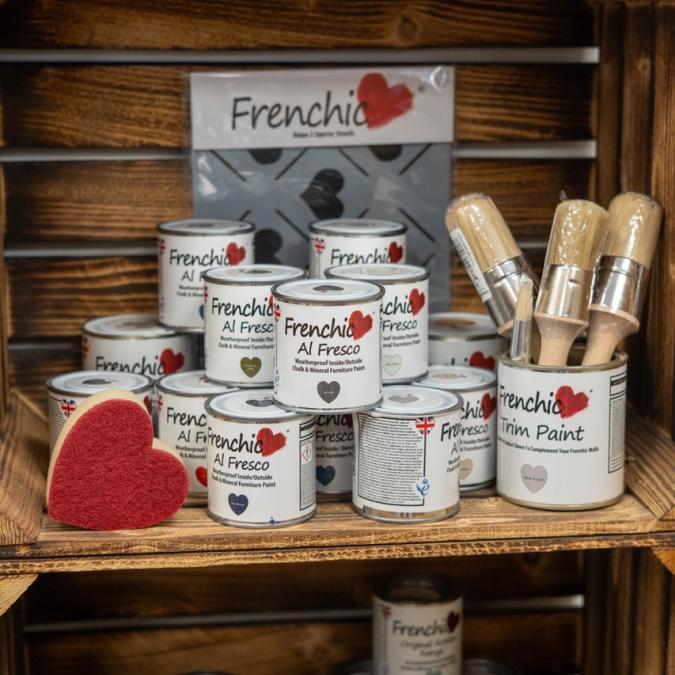 Frenchic paint tins stacked in wooden crate display with paint brushes to the side