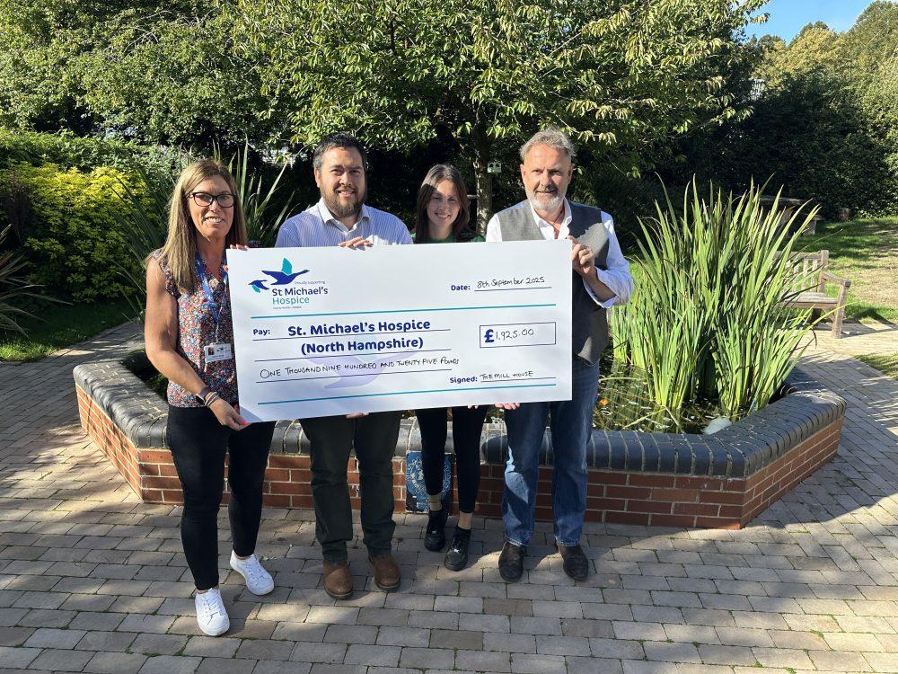 Four people present a large check for £7,036.04 to St. Michael's Hospice.